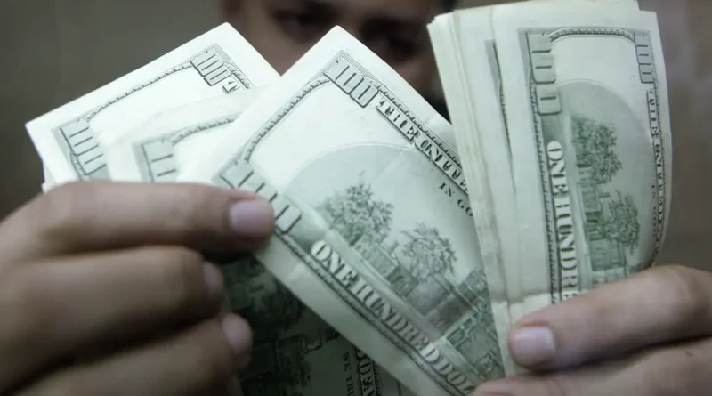 Funcionário de casa de câmbio verifica notas de dólar em Manila 7 de agosto de 2009 REUTERS/Cheryl Ravelo