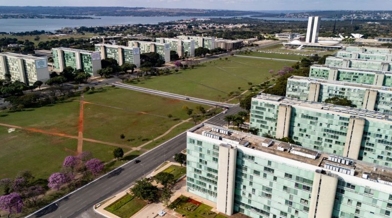22/06/2026 - Brasília - A floração dos ipês-roxos transforma a paisagem de Brasília em um espetáculo de cores que dura apenas algumas semanas, mas deixa marcas na memória durante todo o ano. Considerada uma das árvores mais simbólicas do Cerrado brasileiro, o ipê anuncia a chegada da estação seca justamente quando perde suas folhas e exibe flores em tons vibrantes que contrastam com o céu azul da Esplanada dos Ministérios. Em meio às linhas retas, ao concreto aparente e aos tons cinza característicos da arquitetura modernista idealizada por Oscar Niemeyer, os ipês surgem como protagonistas da paisagem urbana. A explosão de flores roxas quebra a monotonia das formas e colore avenidas, parques e áreas residenciais, criando uma das cenas mais marcantes da capital federal. Breve e intensa, a floração dos ipês lembra que alguns dos mais belos espetáculos da natureza são também os mais passageiros. Foto: Rafa Neddermeyer/Agência Brasil